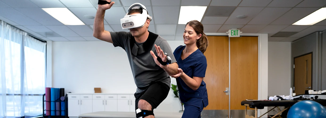 Physical therapist assists a user with REAL System's VR headset for rehabilitation.