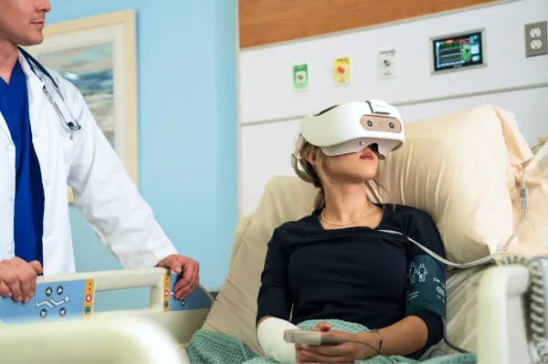 Patient using REAL System VR headset with doctor.